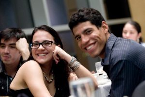 Two people smiling at a conference.