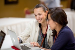 Two conference attendees with a laptop.